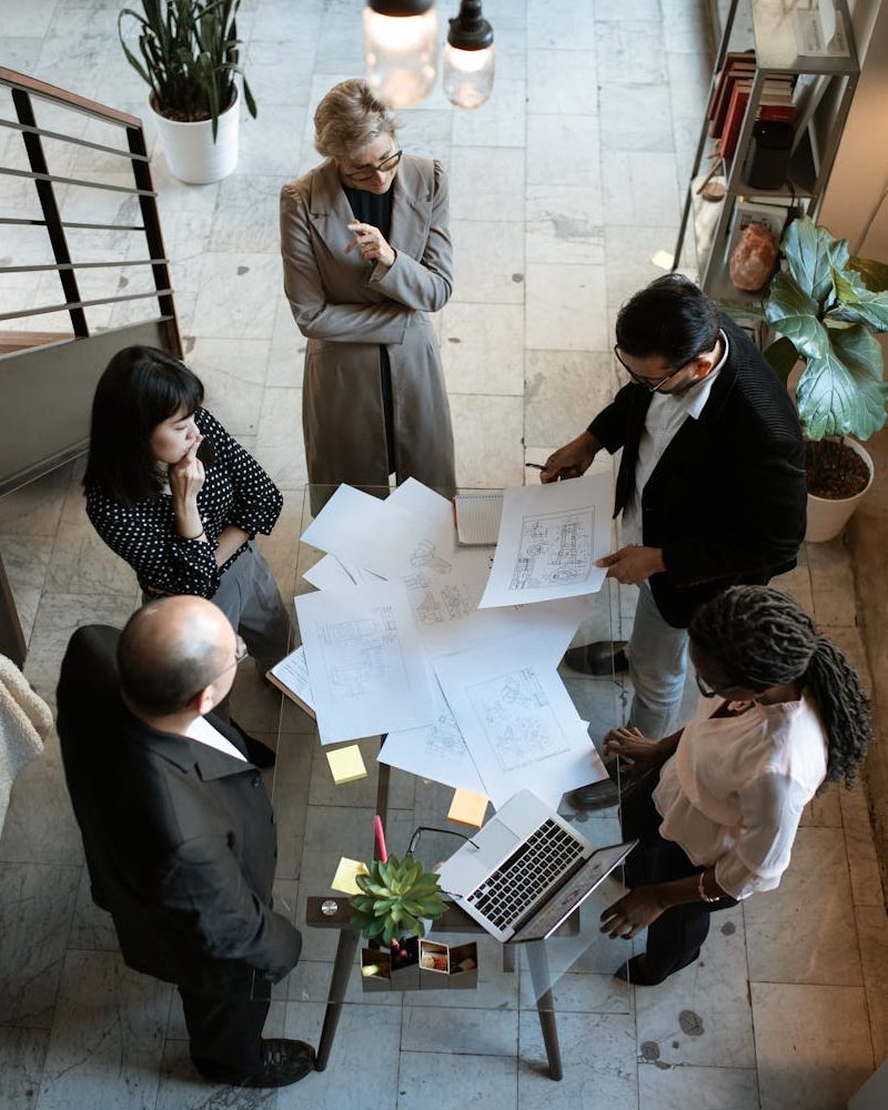 A team of professionals engage in a business meeting in a sleek, modern office setting.
