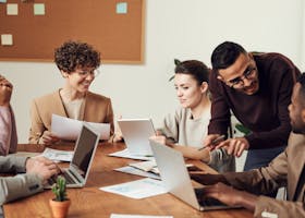 A diverse group of professionals engaged in a collaborative office meeting, sharing ideas and discussing projects.