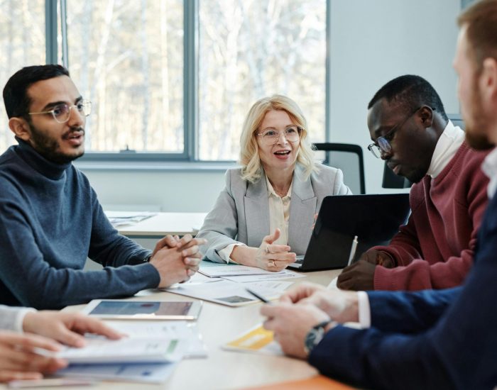 Group of professionals in a meeting discussing teamwork in an office.